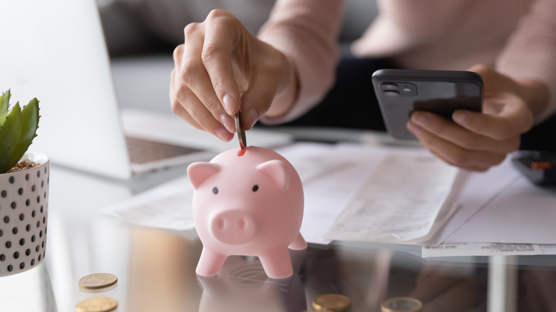 putting money into piggy bank