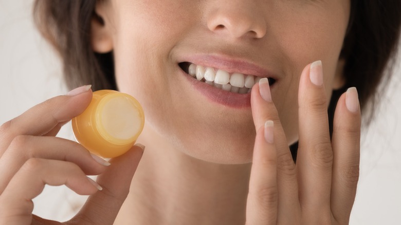 woman applying scrub on lips
