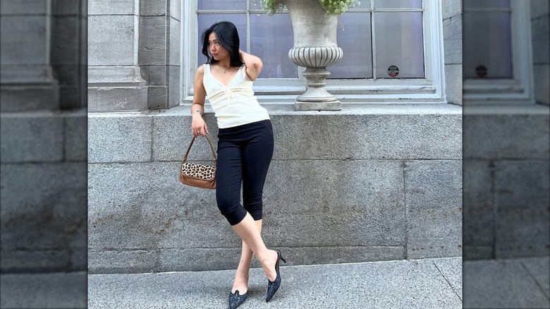 A woman wearing capri pants and kitten heels.