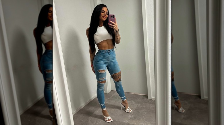 A woman wearing skinny jeans and sandals.