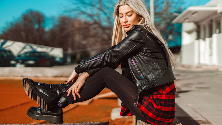 A woman wearing black leggings and chunky boots.