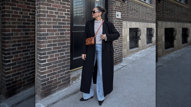 A woman wearing wide jeans and boots.