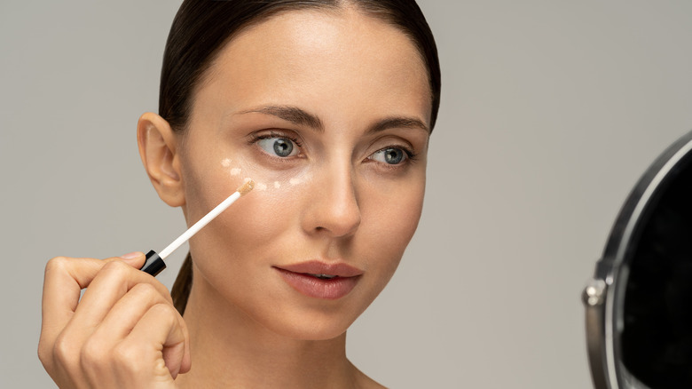 woman applying concealer 