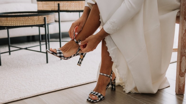 A bride chooses a checkered pair of heels for her wedding outfit