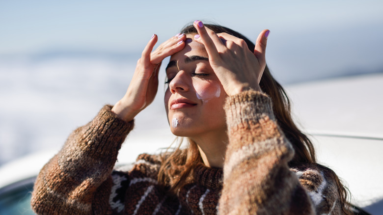Woman applying sunscreen to face