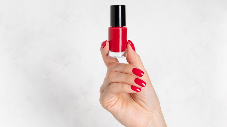 hand holding red nail polish