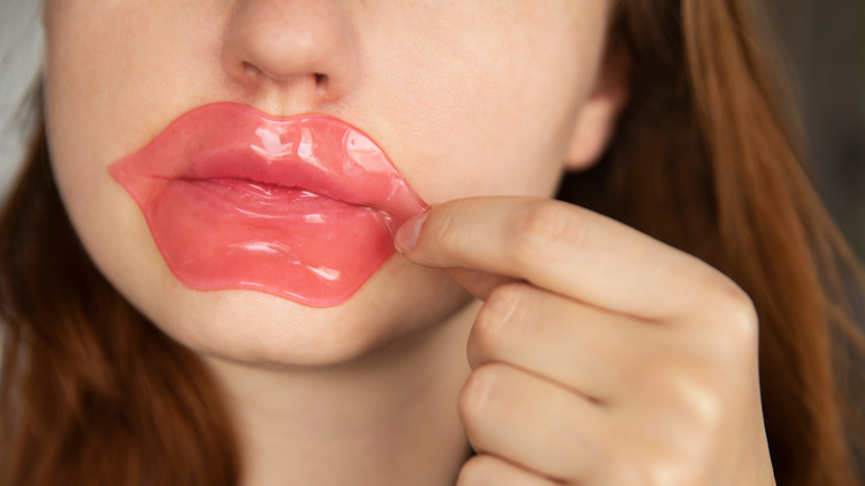 Woman using lip sheet mask