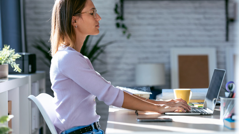 Woman sitting up straight and typing