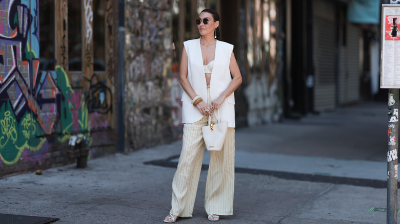 Woman wearing a long vest and pinstriped pants