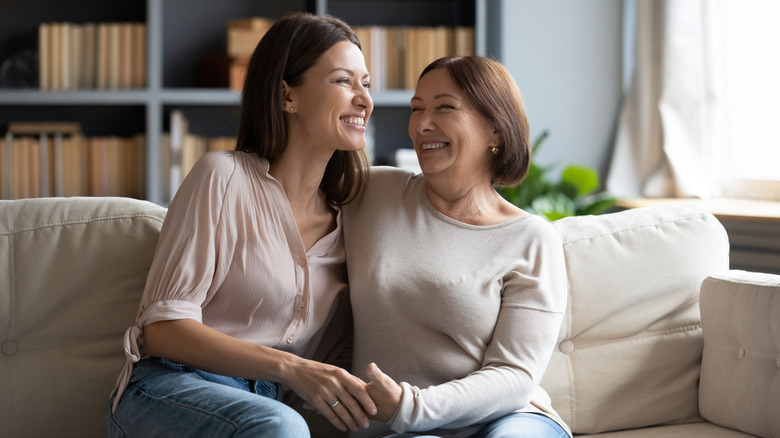 Two women laughing on sofa