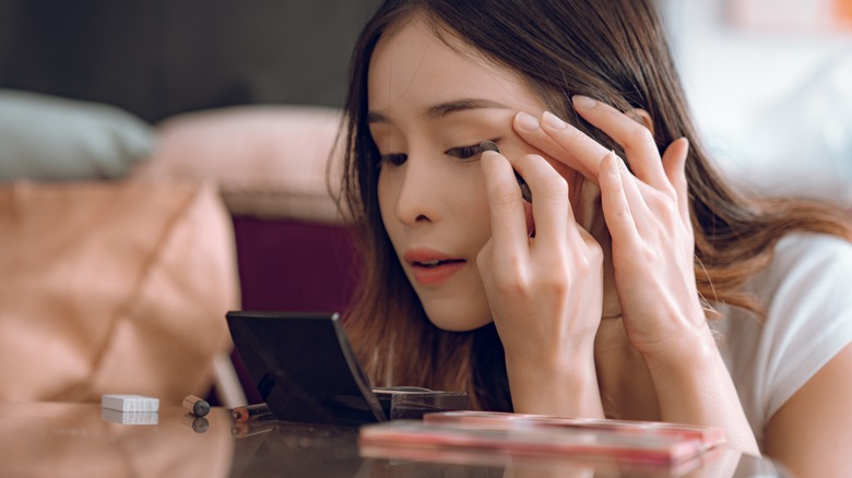 Woman doing eye makeup