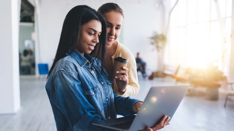 Showing friend something on her laptop