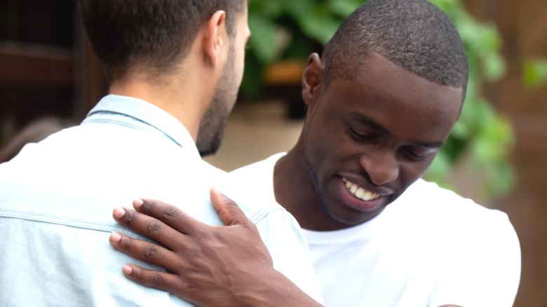Black man hugs his friend