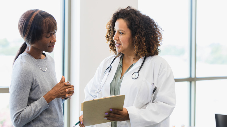 woman sitting on bed looking at hair breakage