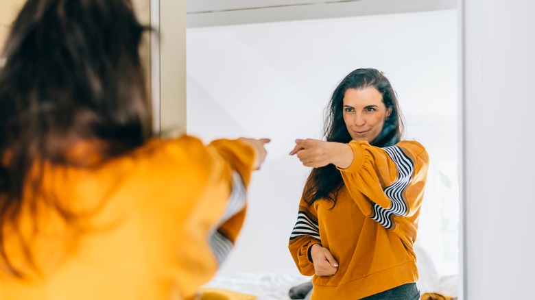 Woman pointing at her reflection