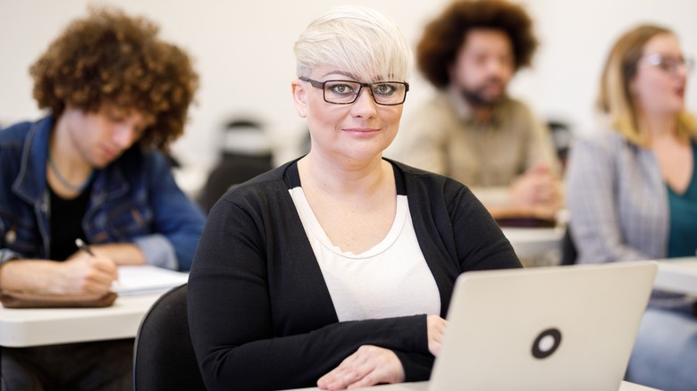 Blond with pixie haircut in class