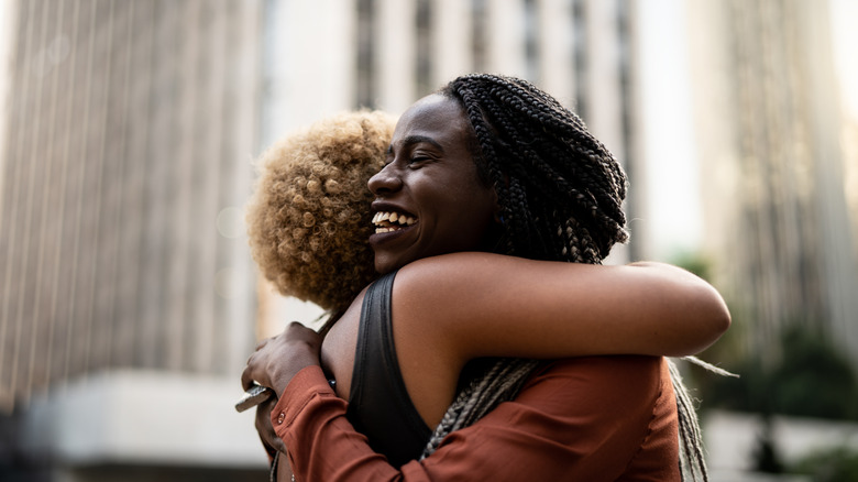 Friends embracing and smiling