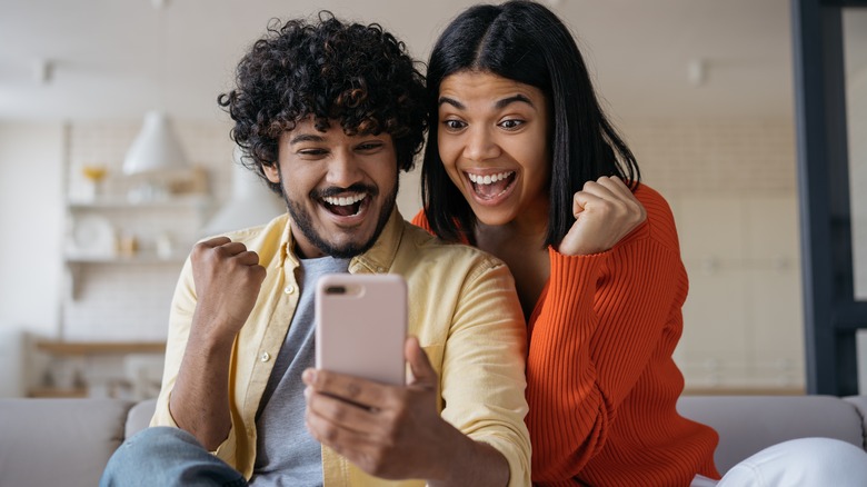 Couple looks at phone excitedly