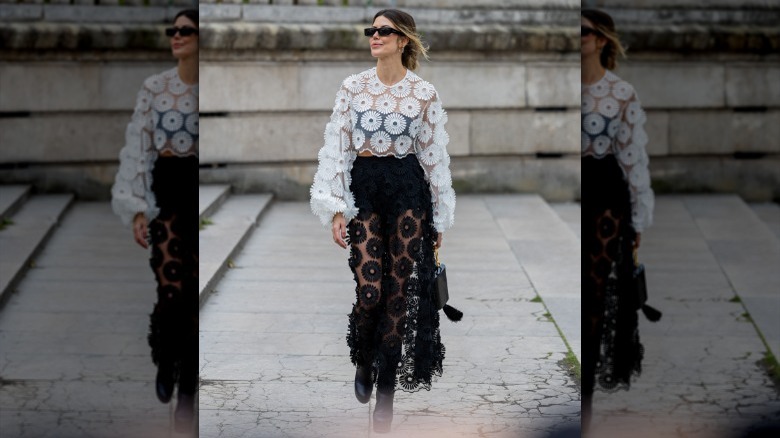 Woman wearing white sheer top, black skirt