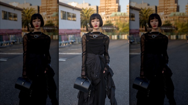 Woman wearing black sheer top, cami