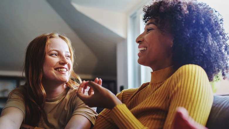 Two women smiling and talking at home