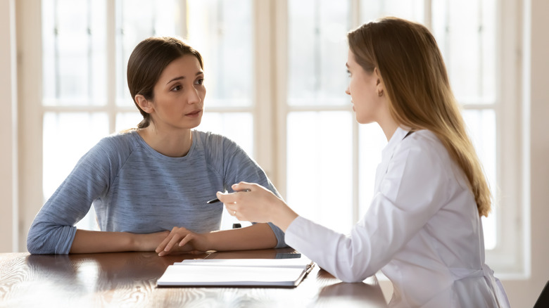 Woman talking seriously to doctor