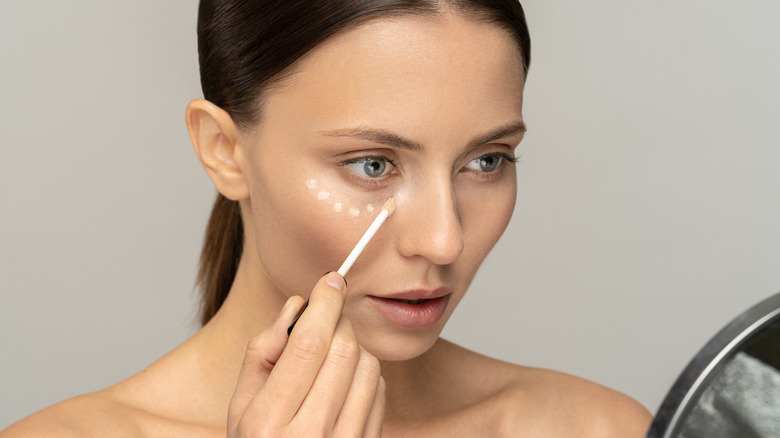 woman applying concealer