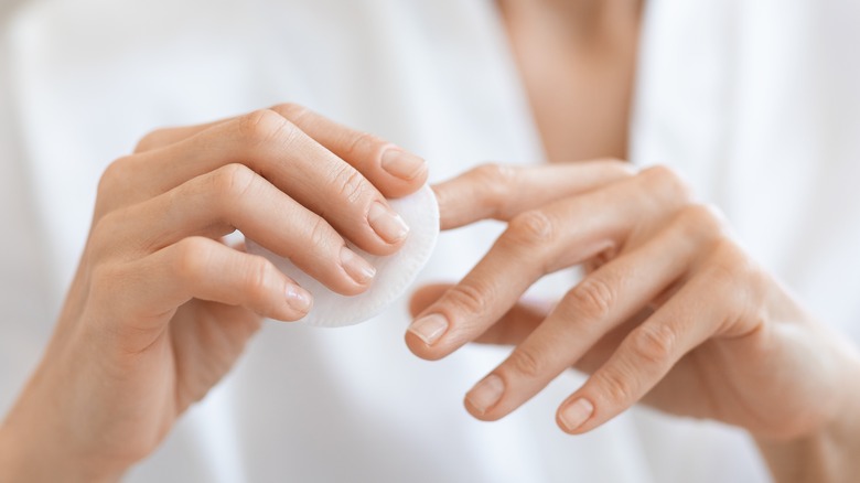 Woman taking off nail polish