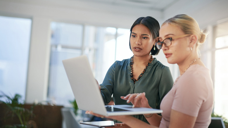 Two focused women looking at laptop