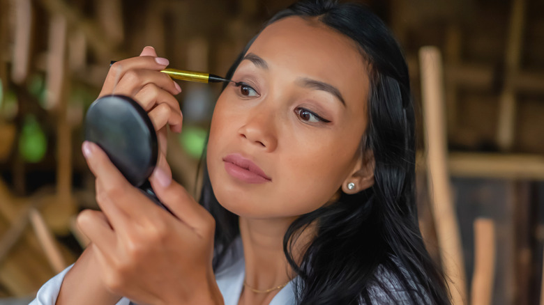 woman applying eyeliner