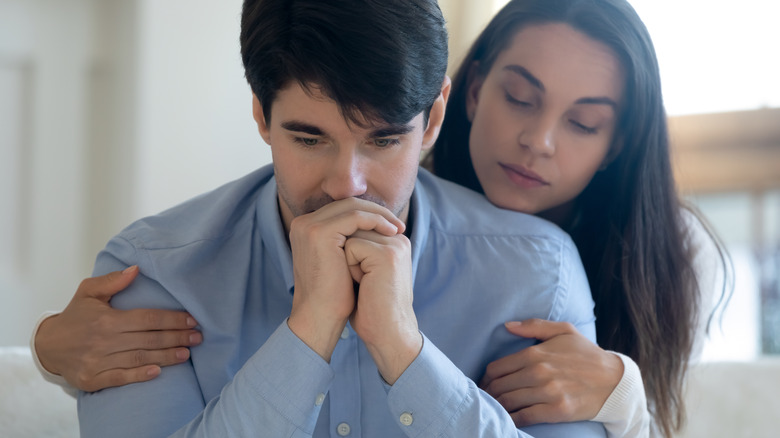 Woman hugging upset man
