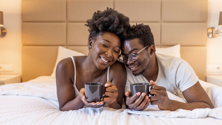 couple drinking coffee in bed