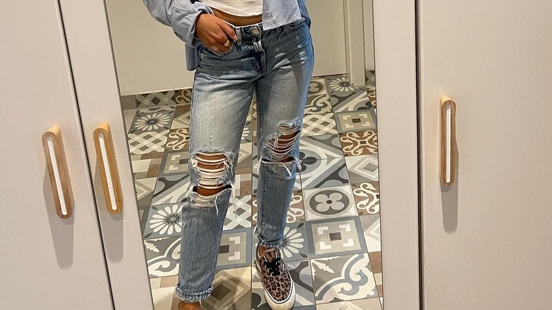 Person wearing ripped jeans, sneakers