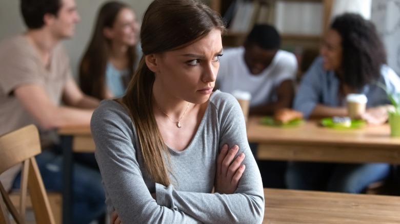 Upset woman turned from friends