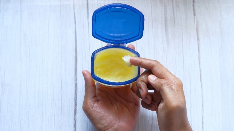 Hand scooping petroleum jelly