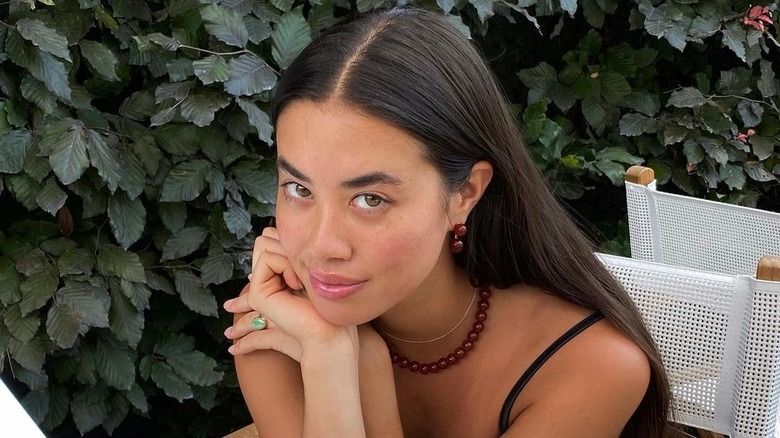 Person with dark hair and middle part