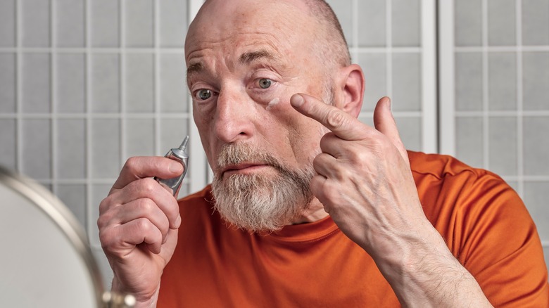 Man applies retinol 