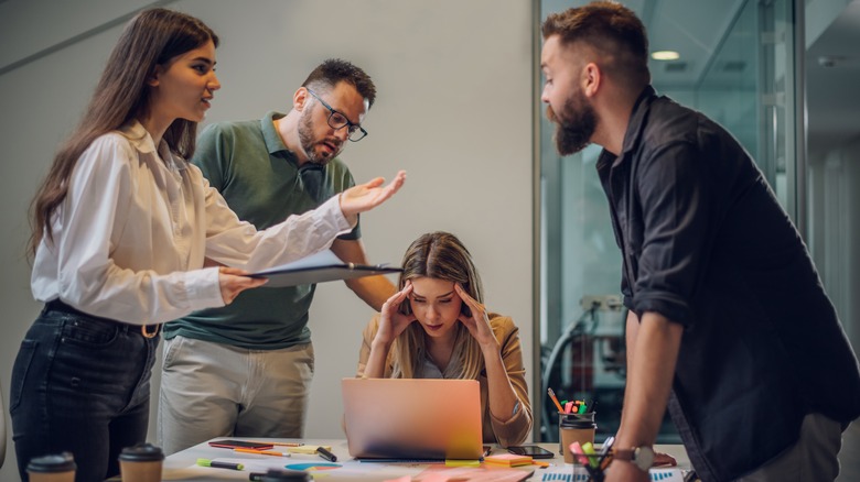 employee in meeting with headache