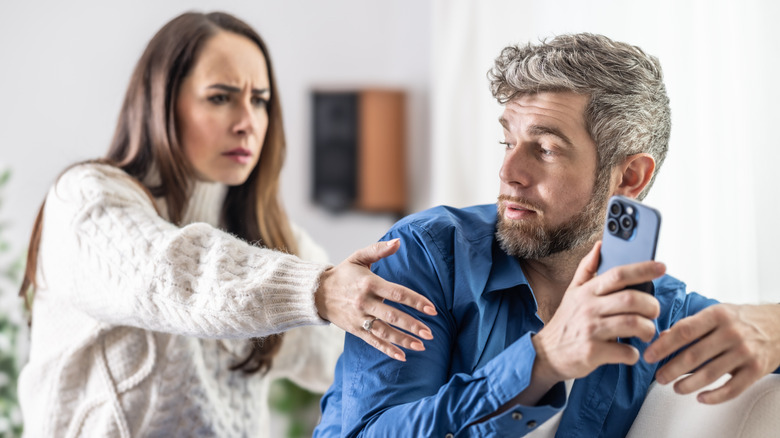 A woman trying to get her partner's phone because she suspects he is lying