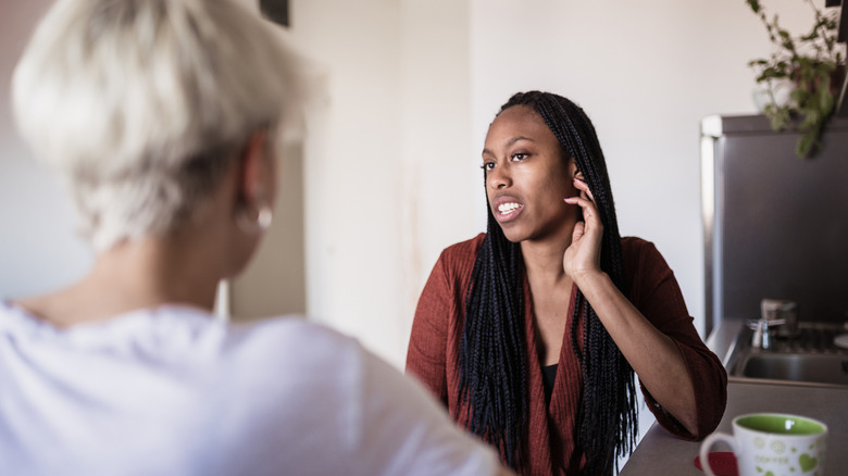 A woman touching her while talking which is a sign of self-soothing while lying