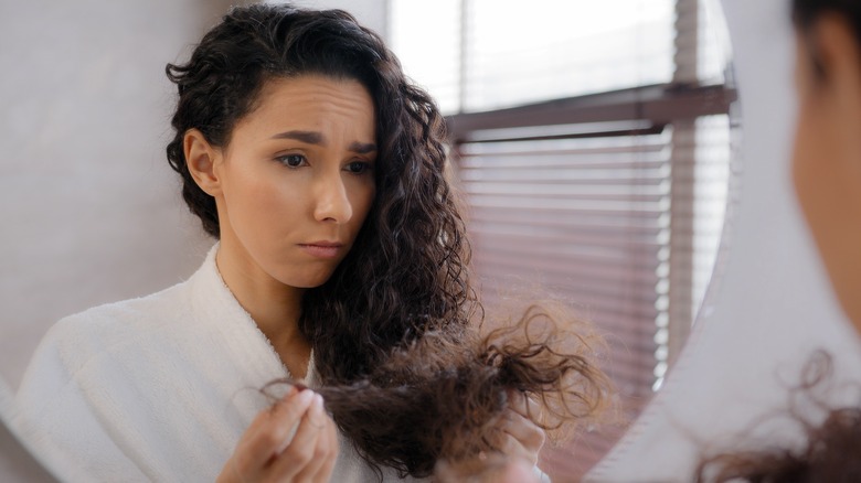 woman looking at brittle hair 