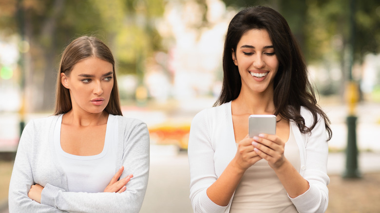 Woman scowling at smiling friend