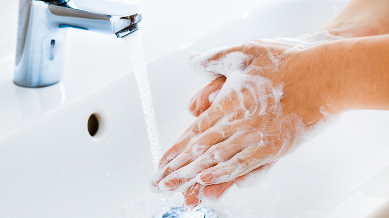 Woman washing hands in sink