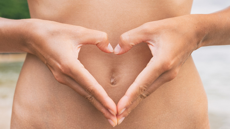 hands held as heart over stomach