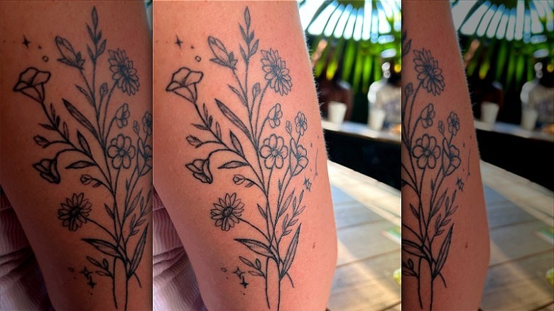 person with botanical arm tattoo