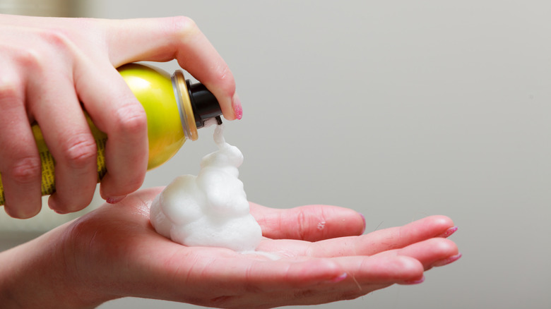 Close-up of mousse being sprayed into hand