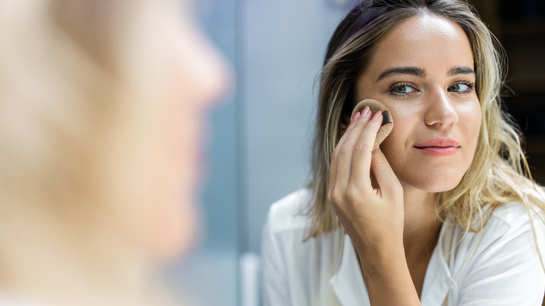 Woman applying her foundation 