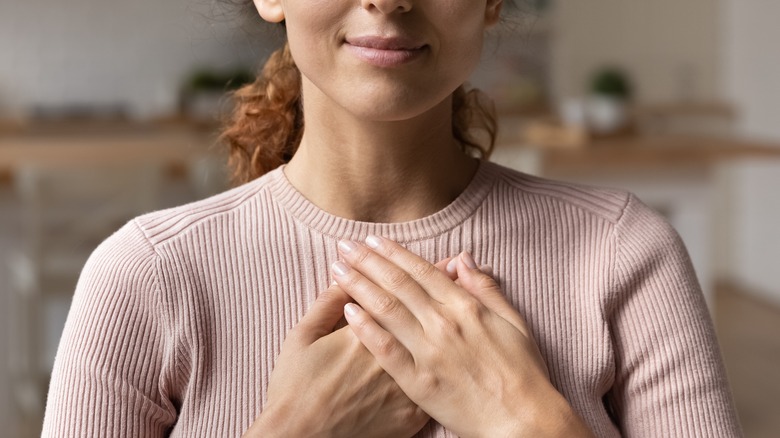 woman holding hands to chest