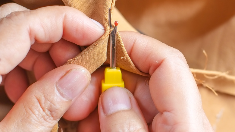 Hands using seam ripper
