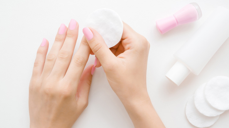 Woman using a makeup round to remove polish